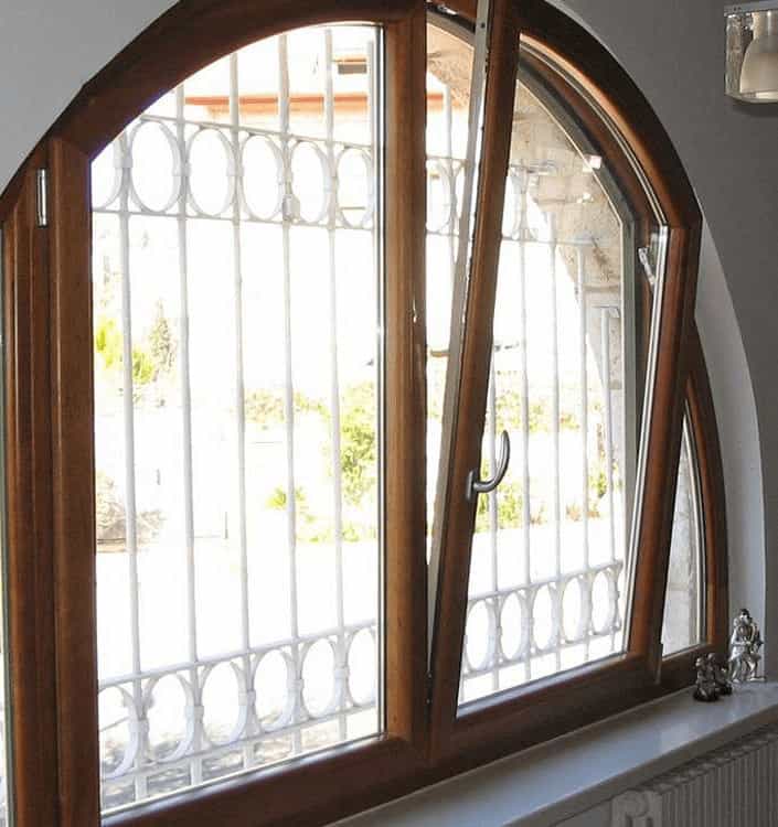 Arched aluminum clad wood window showing tilt-turn design and exterior grill, highlighting design complexities