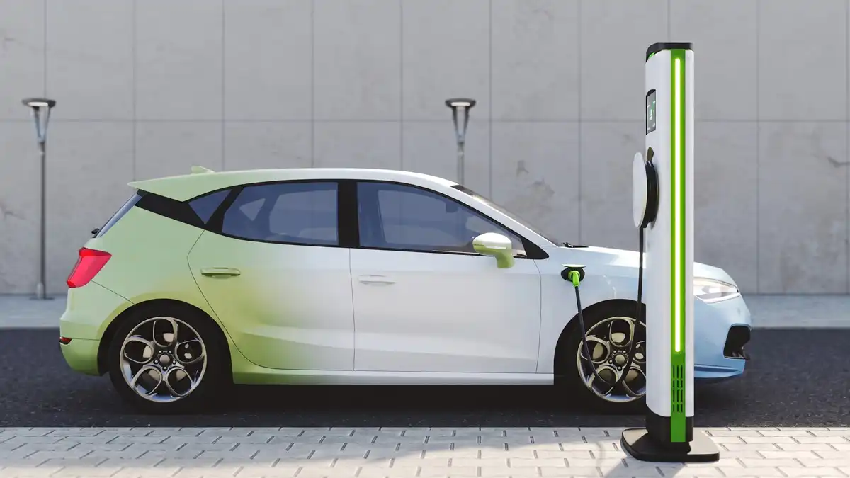 A sleek, sports-style electric car with a custom green and white gradient paint finish charging at a modern EV station, highlighting the use of lightweight aluminium components in next-generation electric vehicles.