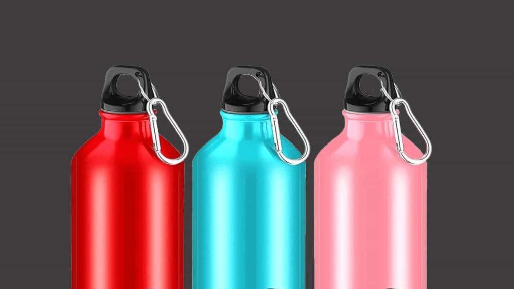 Three brightly colored red, blue, and pink reusable aluminum water bottles, each with a silver carabiner clip, illustrating the variety and style of aluminum designs.