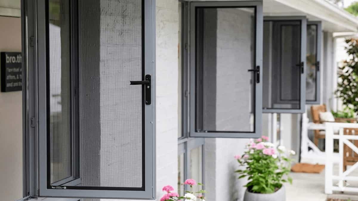 A row of open aluminum casement windows featuring high-quality integrated mesh mosquito nets and black handles.