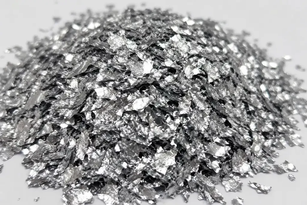 Close-up of shiny aluminium flakes with metallic silver texture used in paints, coatings, pigments, and industrial manufacturing.