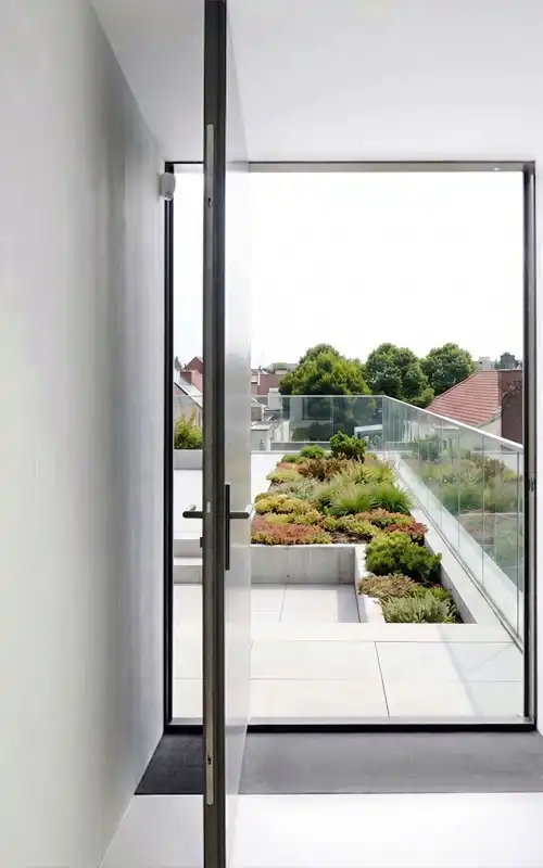 Modern aluminium pivot door installation for an upper-floor balcony or terrace.