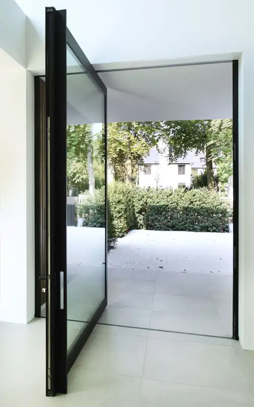 Minimalist aluminium pivot patio door opening to a beautiful landscaped garden.