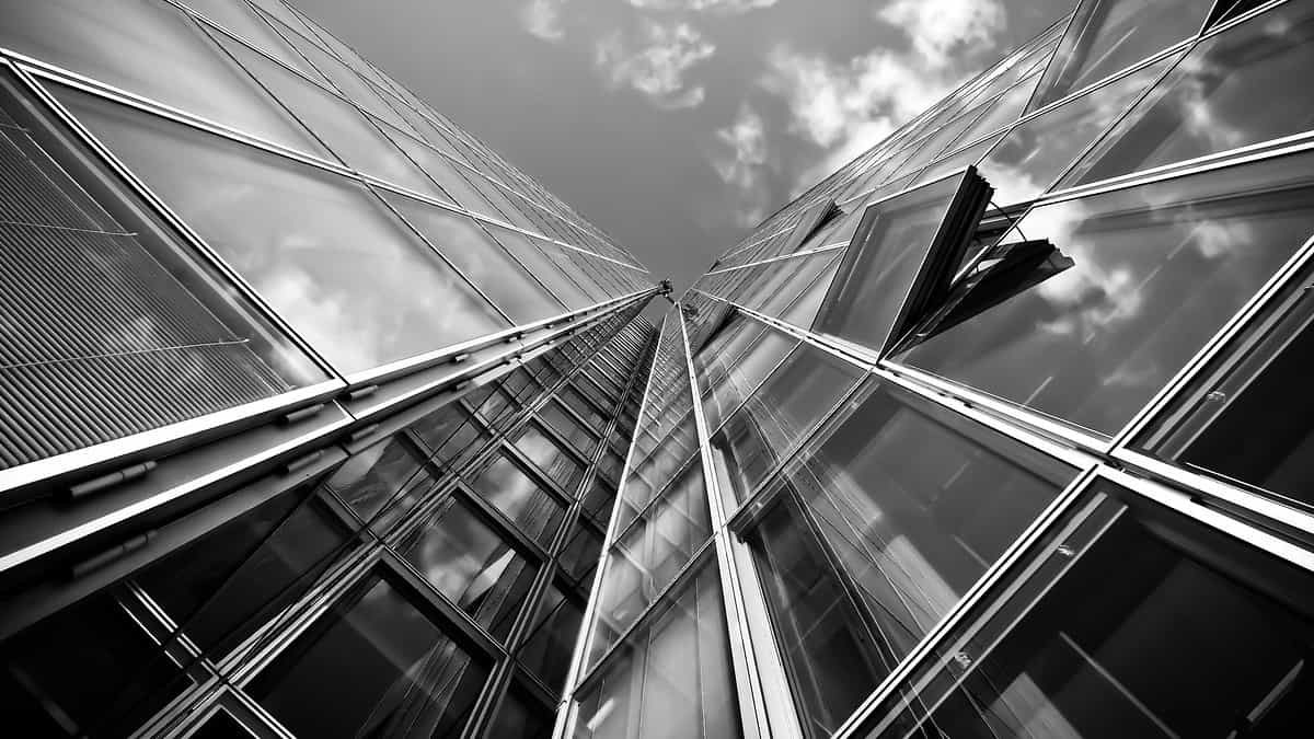 Close-up view of an aluminium structural glazing facade with openable glass panels and reflective curtain wall framing.