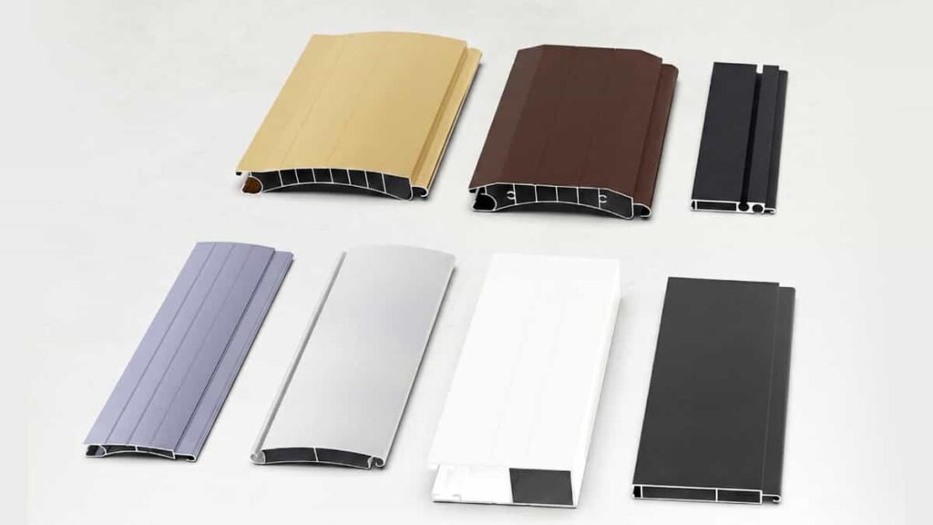 Assortment of aluminum roller shutter slats in various colors including beige, brown, grey, silver, and white, displaying different curved and flat profile designs.