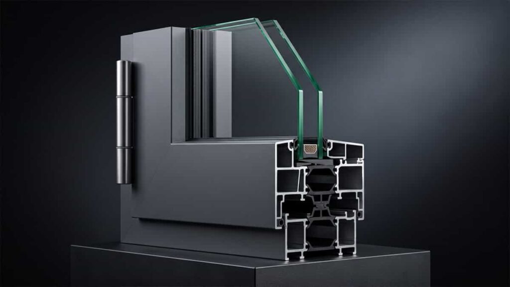 A corner cutaway sample of a modern dark charcoal double glazed window featuring a thermally broken aluminum frame and multi-chamber insulation.
